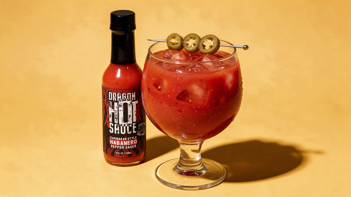 A Dragon's Blood Bloody Mary garnished with pickled jalapeños, next to a bottle of Dragon Caribbean Style Habanero.